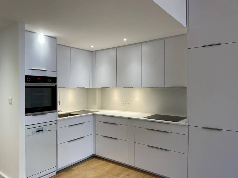 Pose d'une cuisine design blanche sous une mezzanine dans un appartement à Lyon 1