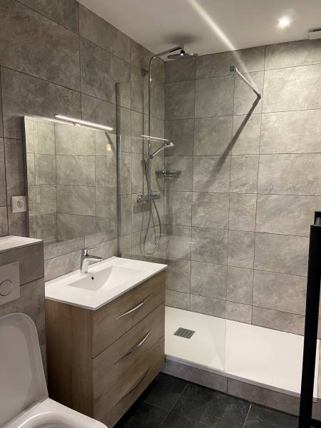 Rénovation d'une salle de bain design avec carrelage bosselé à Lyon 7